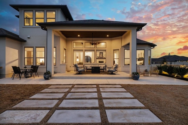 back of property featuring a patio area, a shingled roof, outdoor lounge area, and stucco siding