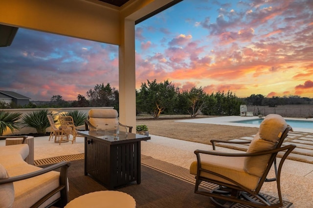 patio terrace at dusk featuring a fenced in pool