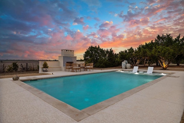 outdoor pool featuring a patio and an outdoor fireplace