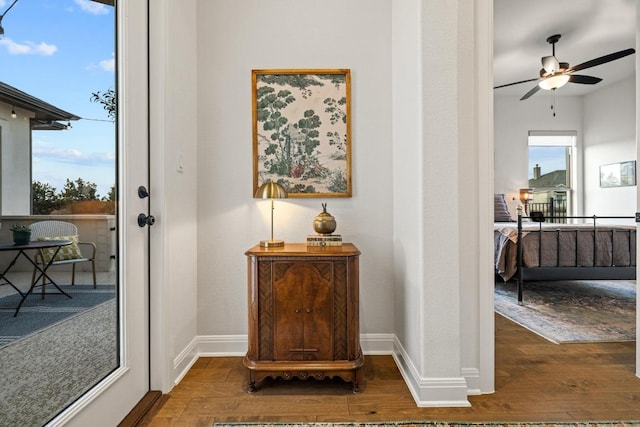 interior space featuring ceiling fan, baseboards, and wood finished floors