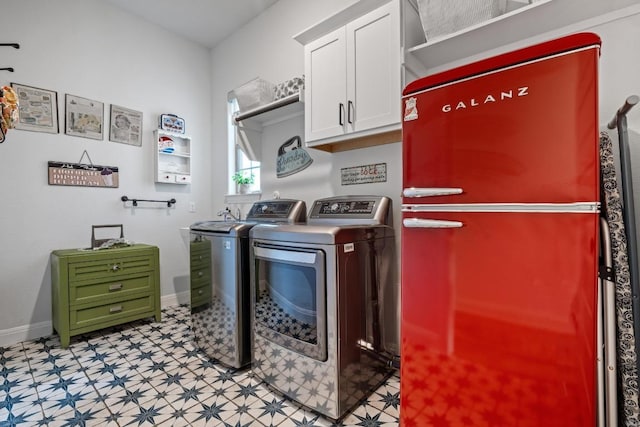 laundry room featuring cabinet space, washing machine and dryer, baseboards, and light floors