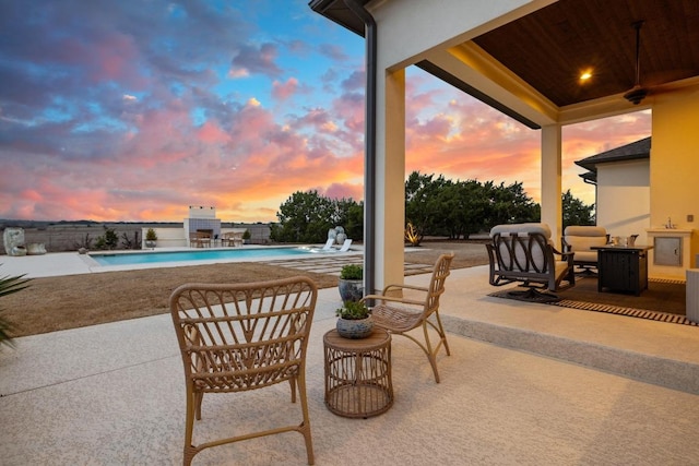 patio terrace at dusk featuring an outdoor pool