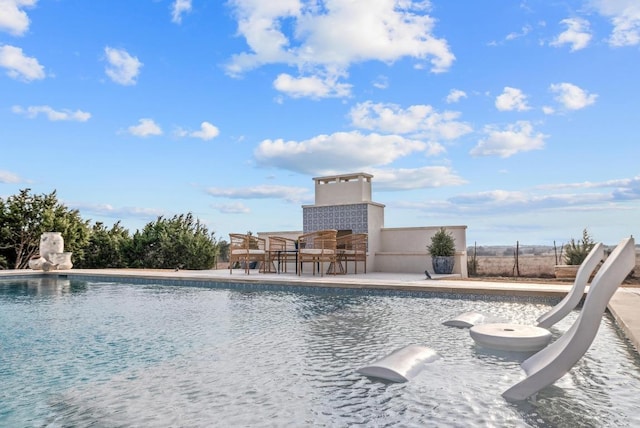 view of swimming pool with a fenced in pool, outdoor dining area, fence, and a patio