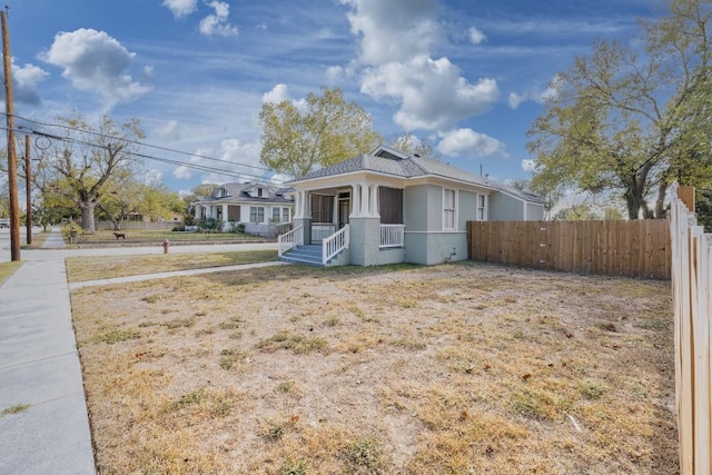 view of front facade with covered porch and fence