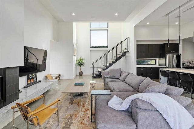 living room with a towering ceiling, stairs, and recessed lighting