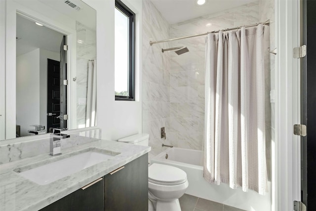 bathroom featuring tile patterned flooring, toilet, vanity, visible vents, and shower / bath combo with shower curtain