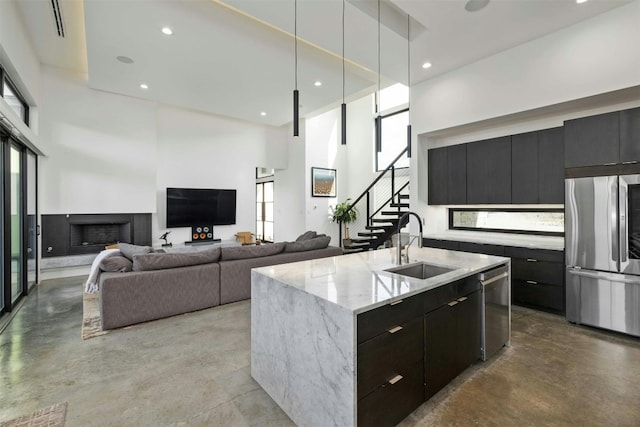 kitchen featuring stainless steel appliances, concrete floors, modern cabinets, and a sink