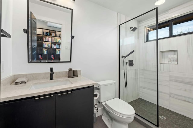 full bath featuring a tile shower, vanity, and toilet