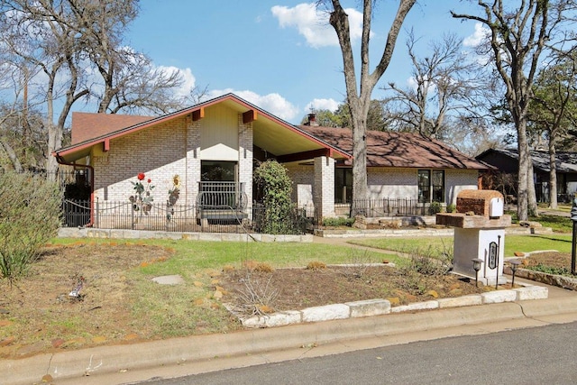 mid-century inspired home with brick siding and a chimney