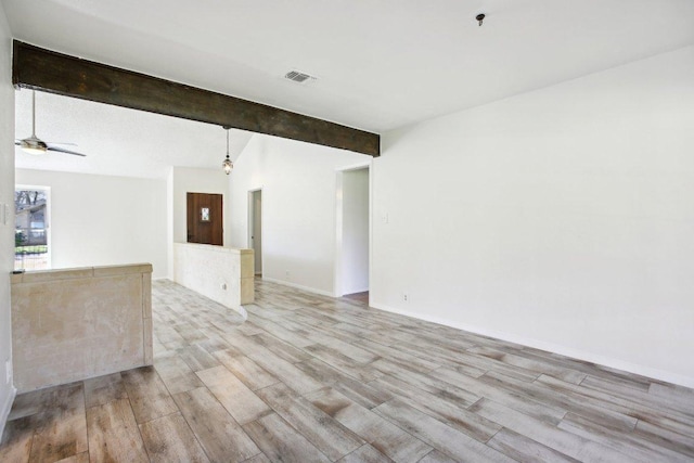 spare room featuring visible vents, baseboards, light wood-style flooring, ceiling fan, and vaulted ceiling with beams