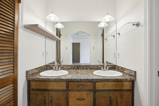 full bathroom with double vanity and a sink