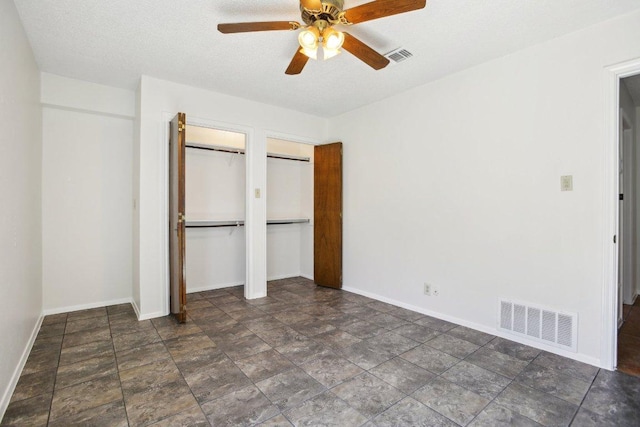 unfurnished bedroom featuring visible vents, ceiling fan, baseboards, and two closets