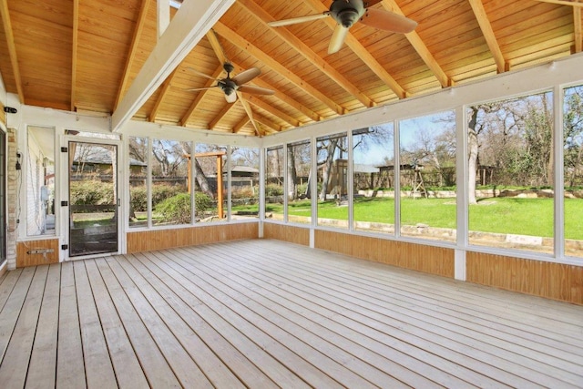 unfurnished sunroom with a ceiling fan, wood ceiling, a healthy amount of sunlight, and vaulted ceiling with beams