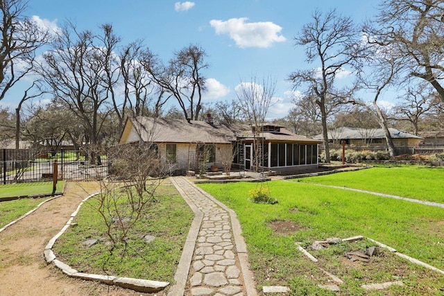 back of house featuring a sunroom, fence, and a yard