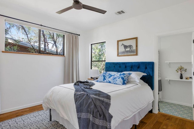 bedroom with visible vents, ceiling fan, baseboards, and wood finished floors