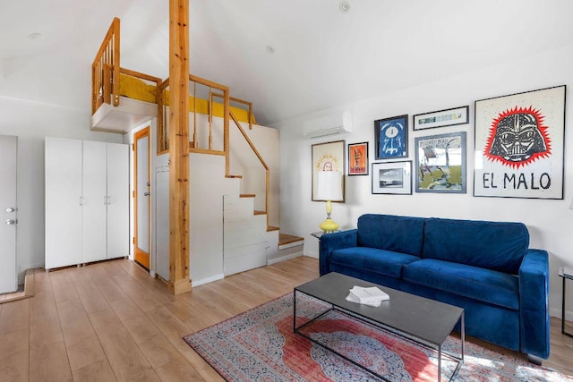 living area with stairs, baseboards, wood finished floors, and a wall mounted AC