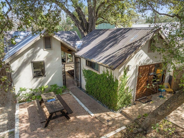 exterior space with metal roof and stucco siding