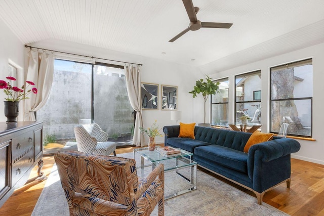 living area with lofted ceiling, wood finished floors, a ceiling fan, and baseboards