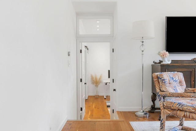 corridor with wood finished floors and baseboards