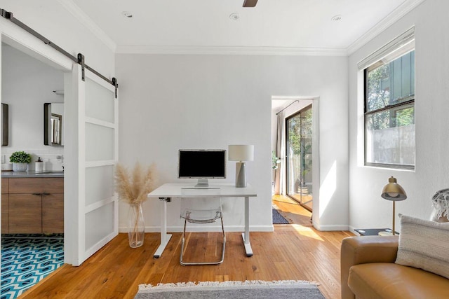 office with ornamental molding, wood finished floors, baseboards, and a barn door