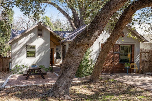 rear view of property featuring a patio area and fence