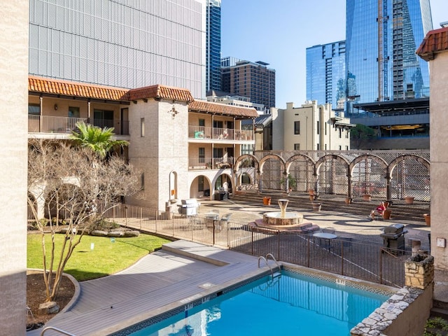 community pool featuring a view of city and fence