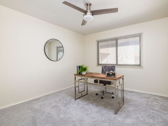 carpeted home office with a ceiling fan and baseboards