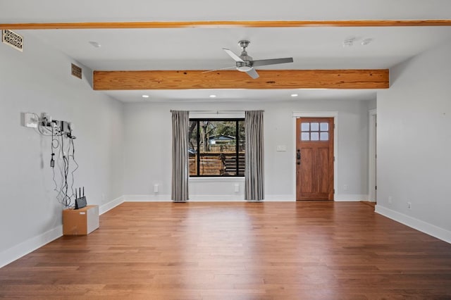 empty room with beam ceiling, recessed lighting, baseboards, and wood finished floors