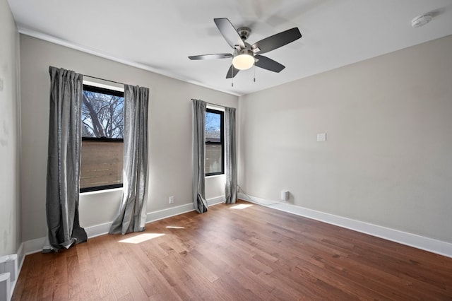 unfurnished room featuring ceiling fan, baseboards, and wood finished floors