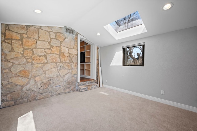 interior space featuring lofted ceiling with skylight, carpet flooring, recessed lighting, and baseboards