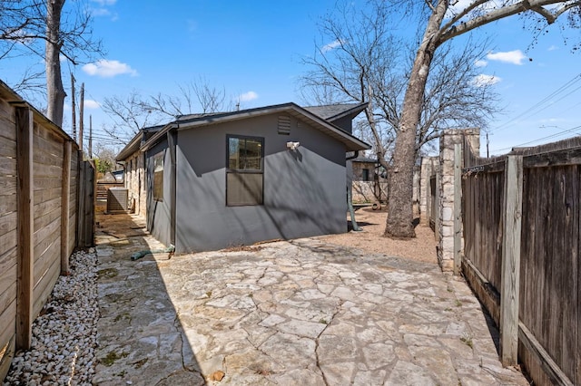 rear view of property with a patio area, stucco siding, and a fenced backyard