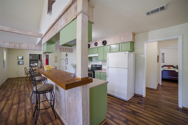 kitchen featuring a peninsula, visible vents, freestanding refrigerator, stainless steel range with electric stovetop, and green cabinetry