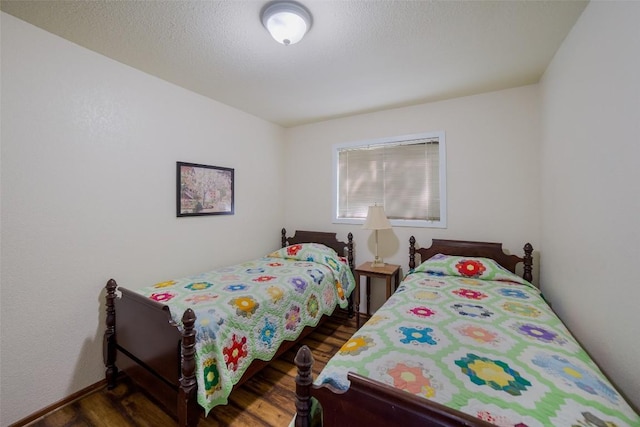 bedroom with a textured ceiling and wood finished floors