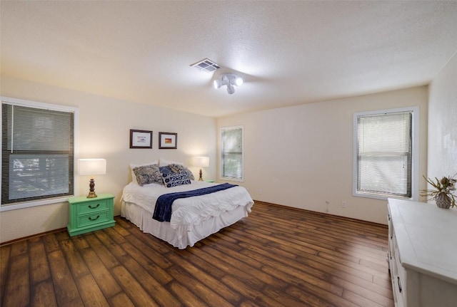 bedroom with visible vents and dark wood-type flooring