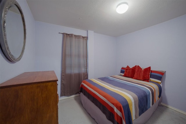 bedroom with finished concrete flooring and a textured ceiling