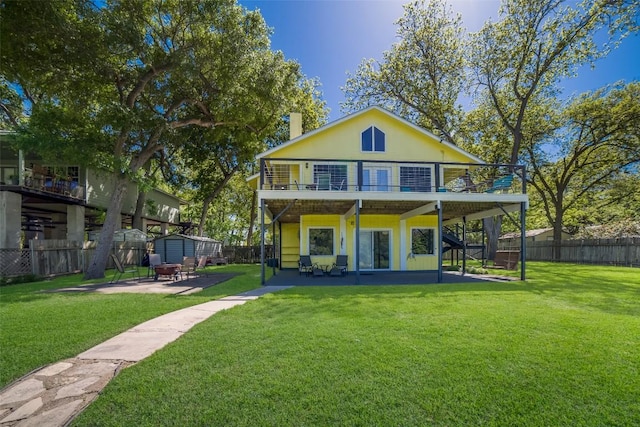 rear view of house with a fenced backyard, stairway, an outdoor structure, a patio area, and a shed