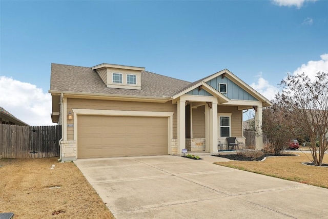 craftsman-style home featuring covered porch, an attached garage, board and batten siding, fence, and driveway