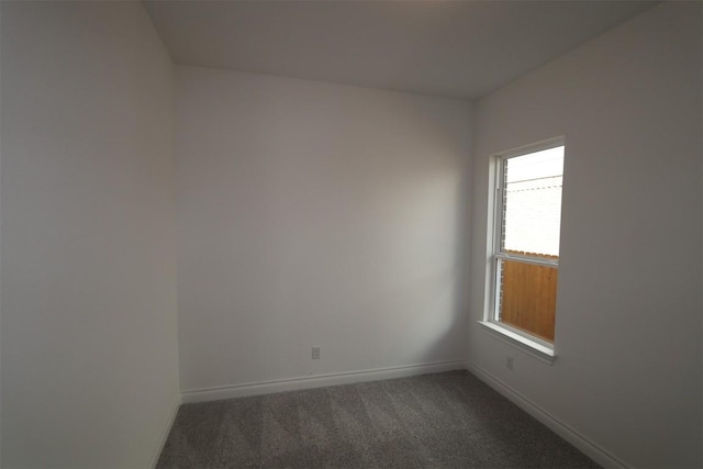 carpeted empty room featuring baseboards