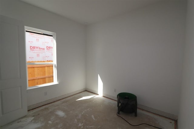 unfurnished room with unfinished concrete flooring