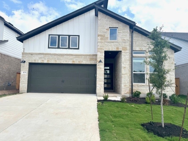view of front facade with board and batten siding, stone siding, and concrete driveway