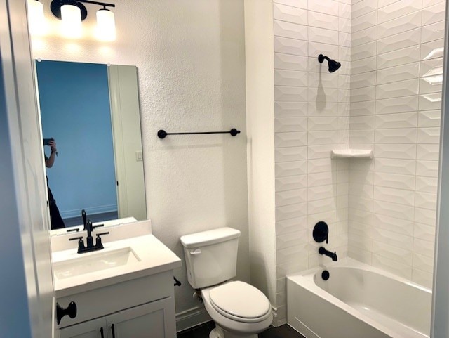 full bath with toilet, a textured wall, bathing tub / shower combination, and vanity
