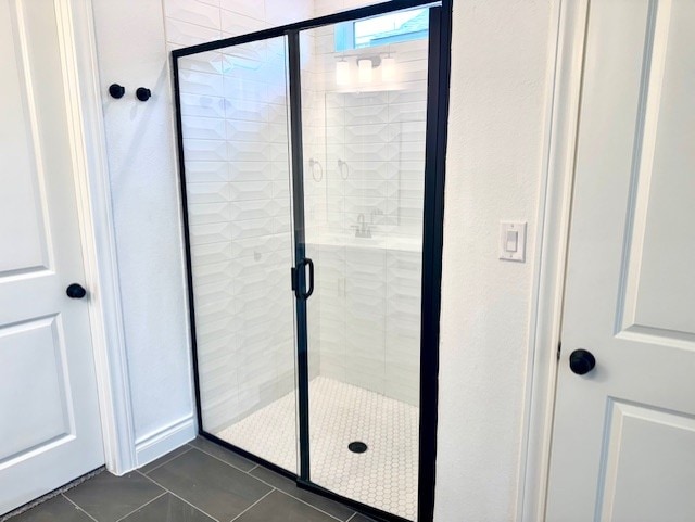bathroom featuring tile patterned flooring and a shower stall