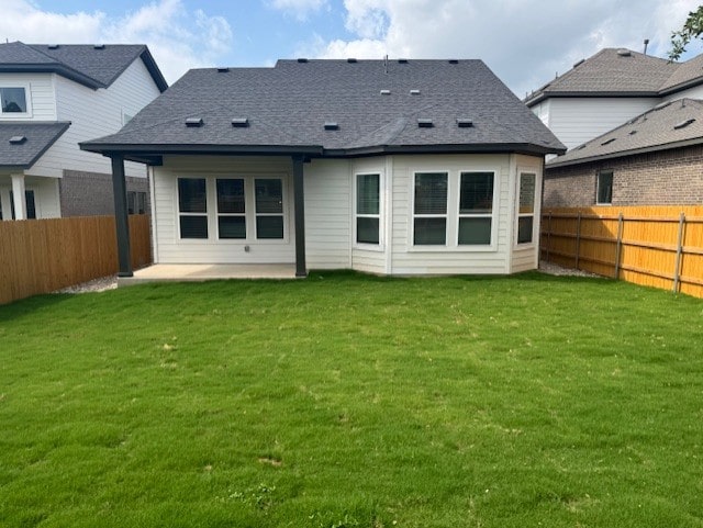 back of property with a yard, a patio, and a fenced backyard