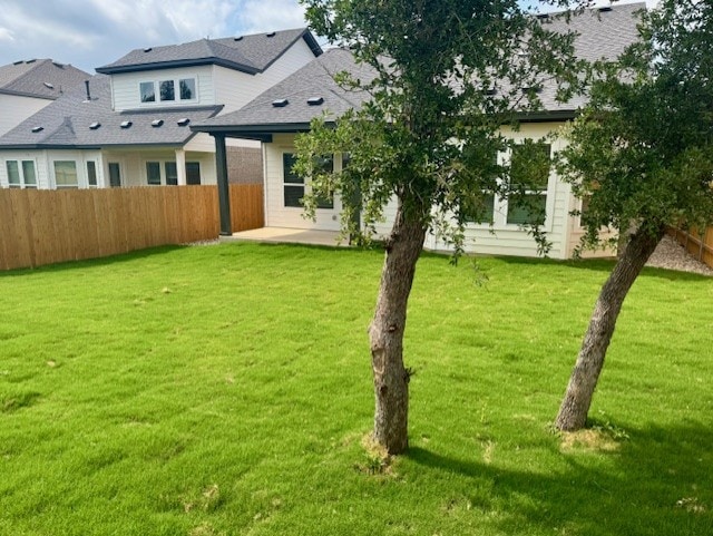 back of house featuring a lawn, a patio area, and fence