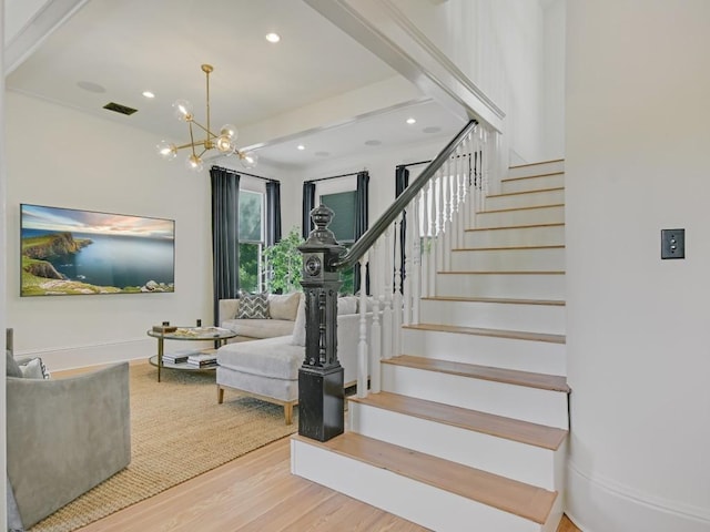 stairs with recessed lighting, wood finished floors, visible vents, baseboards, and an inviting chandelier