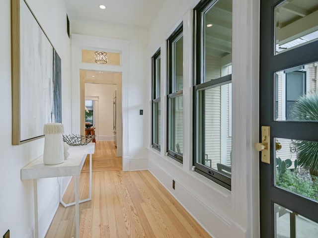 hallway with recessed lighting, a healthy amount of sunlight, baseboards, and wood finished floors