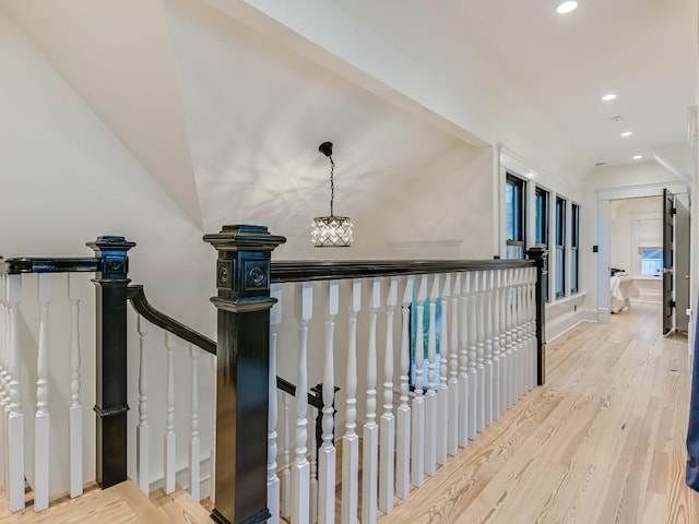 corridor featuring recessed lighting, baseboards, an upstairs landing, and wood finished floors