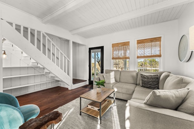 living room with beam ceiling, plenty of natural light, stairway, and wood finished floors