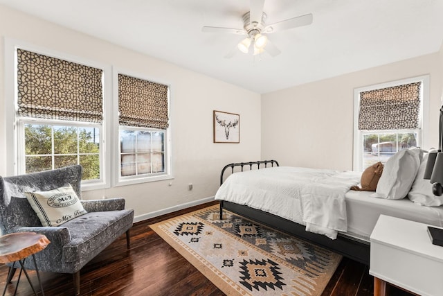 bedroom with dark wood-style flooring, multiple windows, ceiling fan, and baseboards