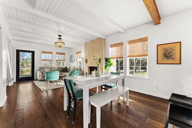 dining room with a large fireplace, baseboards, wood ceiling, dark wood-style flooring, and beamed ceiling